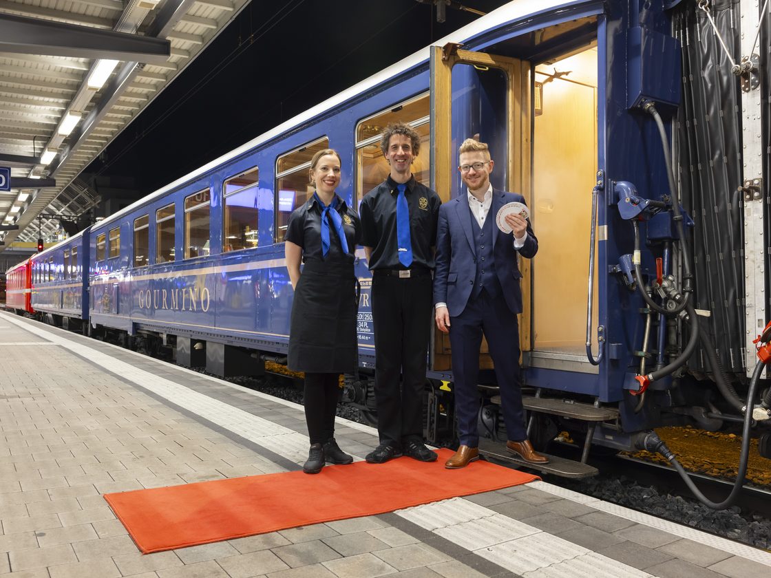 Der königsblaue Speisewagen Gourmino, angekuppelt an einen roten Triebwagen der Rhätischen Bahn